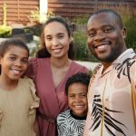 Smiling multicultural family enjoying time together outdoors in their garden.